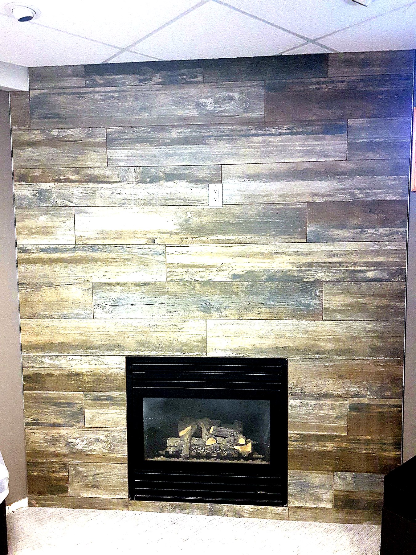Finished Winnipeg basement with built-in fireplace feature wall and custom shelving