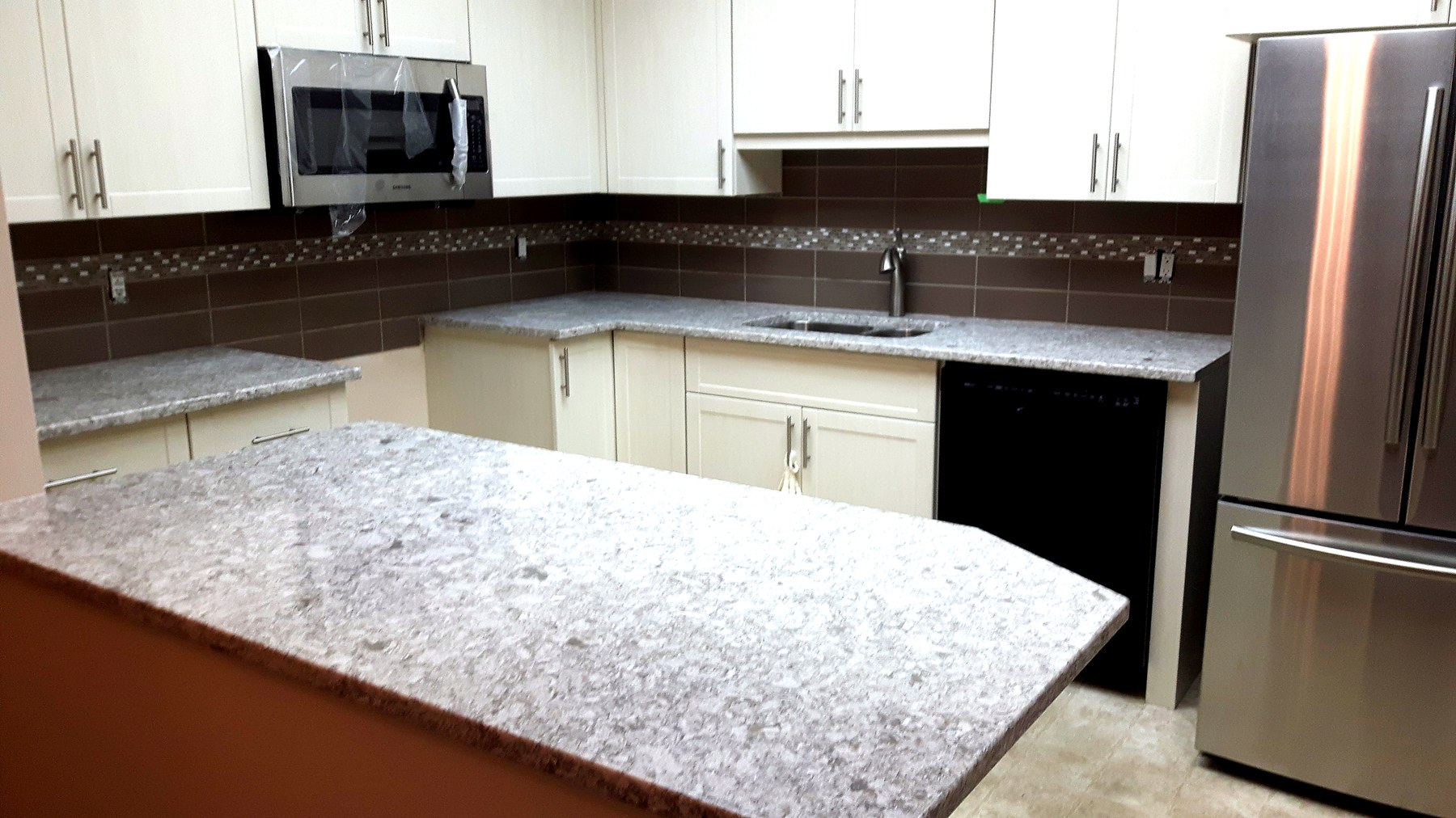 Luxury kitchen renovation Winnipeg — dark navy cabinetry with marble waterfall island